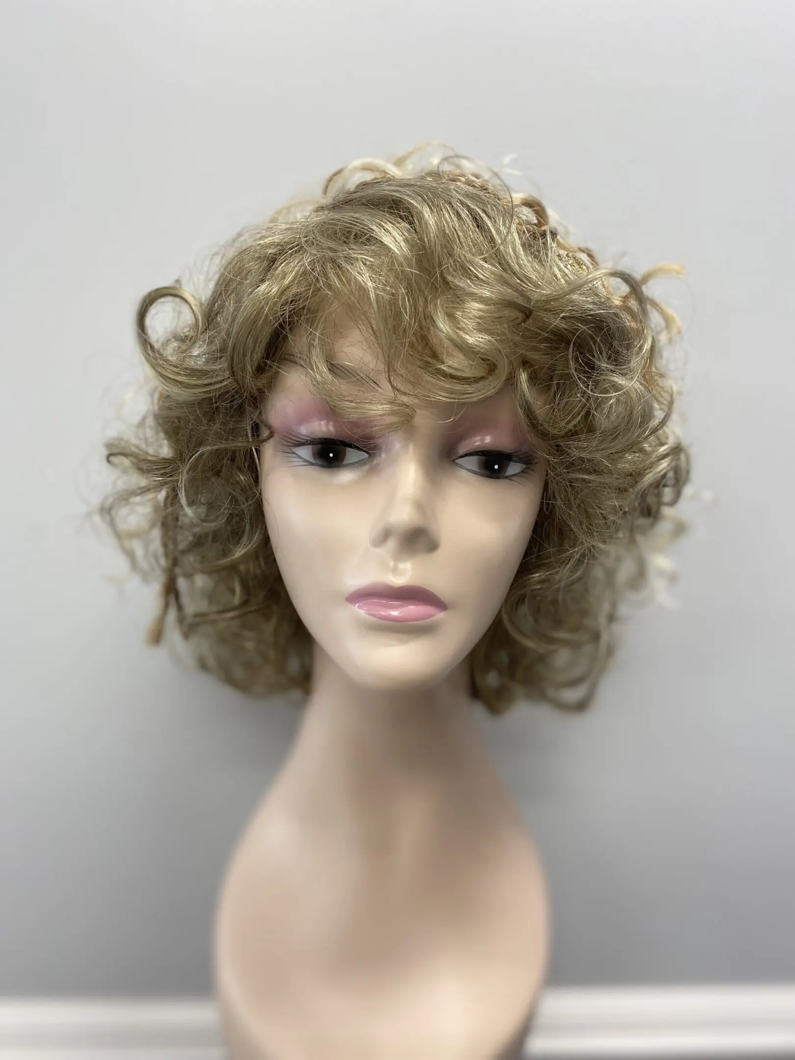 Blonde curly bob wig on mannequin.